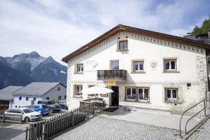 a white building with cars parked in front of it at Chasa Macun in Schleins