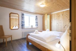 a bedroom with a bed in a room with wooden walls at Chasa Macun in Schleins