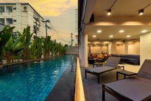 a hotel pool with chairs and tables on a balcony at Lantern Chiang Mai Night Bazaar Hotel in Chiang Mai
