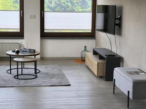 a living room with a table and a tv at FeWo 180° MOSELWeitblick in Neumagen-Dhron