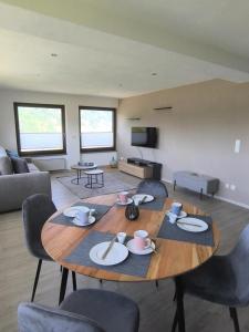 a living room with a wooden table and chairs at FeWo 180° MOSELWeitblick in Neumagen-Dhron