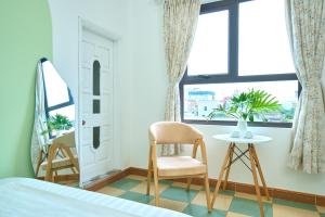 a bedroom with a bed and a chair and a table at Sunny - Việt House in Kỳ Vĩ