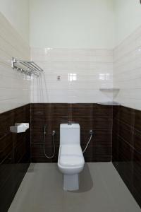 a bathroom with a white toilet in a stall at Heaven Stay in Varkala +17 photos