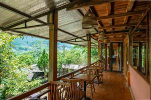 a porch with chairs and tables and a view at Vanhaus in Sapa