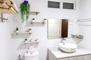 a white bathroom with a sink and a mirror at Cebu Airport Layover Stay in Pusok +5 photos