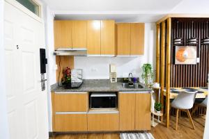 a kitchen with wooden cabinets and a sink and a table at Cebu Airport Layover Stay in Pusok