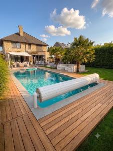 a swimming pool with a wooden deck and a house at O’Berges D’Astacus in Beloeil