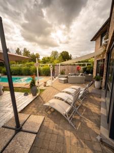 a patio with lounge chairs and a swimming pool at O’Berges D’Astacus in Beloeil