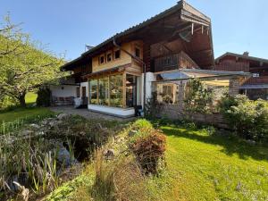 a wooden house with a lawn in front of it at Ferienwohnung Bachl inkl. Chiemgaukarte in Ruhpolding