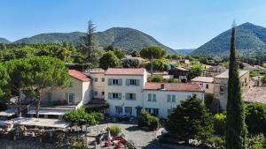 a house in a village with mountains in the background at Auberge de l'Escargot d'Or in Dieulefit