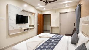 a hotel room with two beds and a tv at Hotel GVR Prime in Guntūr