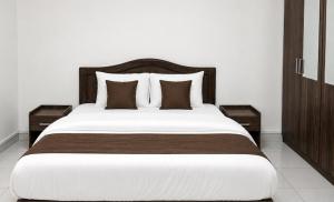 a bedroom with a large bed with two night stands at Today House Suites 5 in Salalah