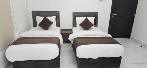 two beds in a room with white and brown at Today House Suites 5 in Salalah +18 photos