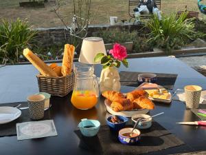 a table with food and a jug of orange juice and bread at Caravane revisité in Pleslin-Trigavou