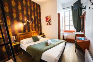a hotel room with a bed and a window at Auberge de l'Escargot d'Or in Dieulefit