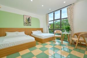 a bedroom with two beds and a table and a chair at Sunny - Việt House in Kỳ Vĩ