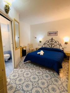 a bedroom with a blue bed and a toilet at La Villa Resort e Spa in Forio d'Ischia +52 photos