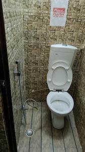 a bathroom with a white toilet in a stall at Accommodation In Prayagraj, Near Railway Station Triveni Sangam, Allahabad in Prayagraj