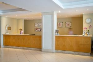 a woman sitting at a counter in a waiting room at Atlantica Miramare Beach in Limassol +99 photos