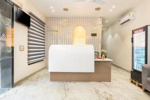 a lobby with a white reception desk and a tv at asar Varanasi Junction by Orion Hotels in Varanasi