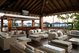a patio with couches and chairs on a beach at Atlantica Miramare Beach in Limassol