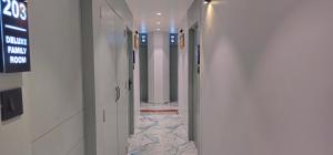 a hallway with white walls and a tile floor at Hotel Prime Gold in Ahmedabad