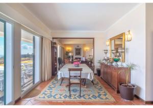 a dining room with a table and a kitchen at Villa Amelia in Caniço