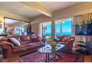 a living room with leather couches and a tv at Villa Amelia in Caniço