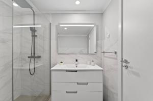 a white bathroom with a sink and a shower at Calheta Atlantic Pearl in Calheta +41 photos