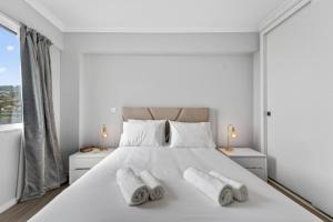 a white bedroom with a large white bed with three pillows at Calheta Atlantic Pearl in Calheta
