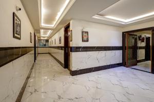 a hallway with marble flooring and a wall with a window at Lavanya Hotel- Near Alipur, Delhi in New Delhi +53 photos