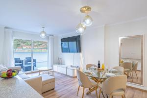 a living room with a table and a dining room at Sunflower Apartment in Caniço