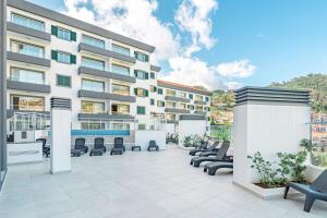 an outdoor patio with chairs and a building at Sunflower Apartment in Caniço