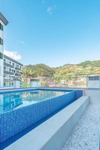 a swimming pool on the side of a building at Sunflower Apartment in Caniço