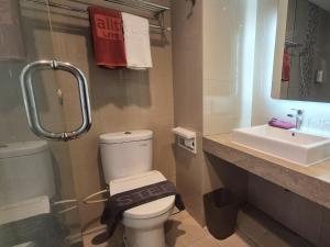 a bathroom with a toilet and a sink at Alltrue Lite Senen Jakarta in Jakarta +6 photos