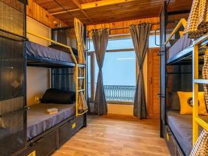 a bedroom with bunk beds in a room with a window at The Hosteller Chakrata in Chakrāta