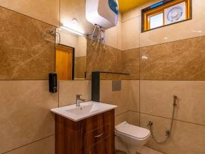 a bathroom with a sink and a toilet at The Hosteller Chakrata in Chakrāta