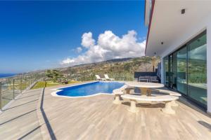a patio with a table and a swimming pool at Celeste Villa in Ribeira Brava