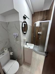 a bathroom with a toilet and a sink and a mirror at Rulers Smart Rooms in Satu Mare