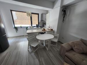 a living room with a table and a kitchen at Apartment By The Lake with a View in Mamaia