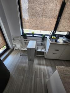 a kitchen with a table and a sink and a window at Apartment By The Lake with a View in Mamaia