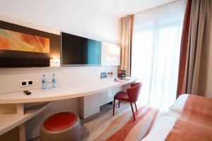 a hotel room with a desk and a bed at Hotel Kapuzinerhof in Biberach an der Riß