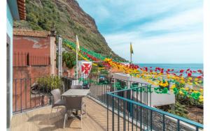 a balcony with a table and chairs and the ocean at Jardim Mar Flats in Jardim do Mar