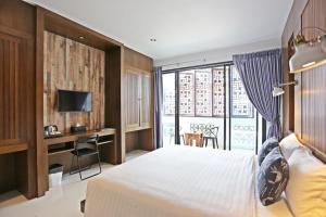 a bedroom with a bed and a desk with a window at Guan Yu Boutique Hotel in Ban Thong Yi +8 photos