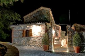 a stone house with lights on the side of it at Il Giuncheto in Trequanda
