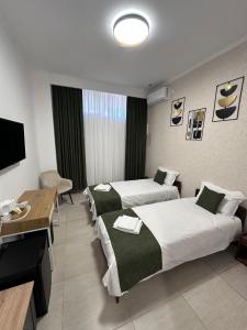 a hotel room with two beds and a table at Rulers Smart Rooms in Satu Mare +8 photos