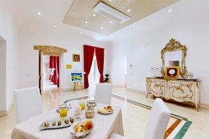 a dining room with a table and chairs and a mirror at B&B Palazzo del Teatro in Agrigento