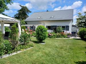a house with a garden with flowers at Dreiflüsse Appartement - Traumgarten mit Grill und Pavillon, WLAN, Küche und Parkplatz in Salzweg