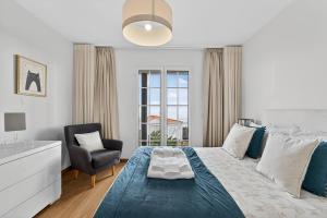 a bedroom with a bed and a chair and a window at Florentina Villa in Gaula