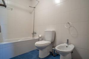 a white bathroom with a toilet and a sink at Front beach Apartment in Paul do mar 9 in Paul do Mar +14 photos